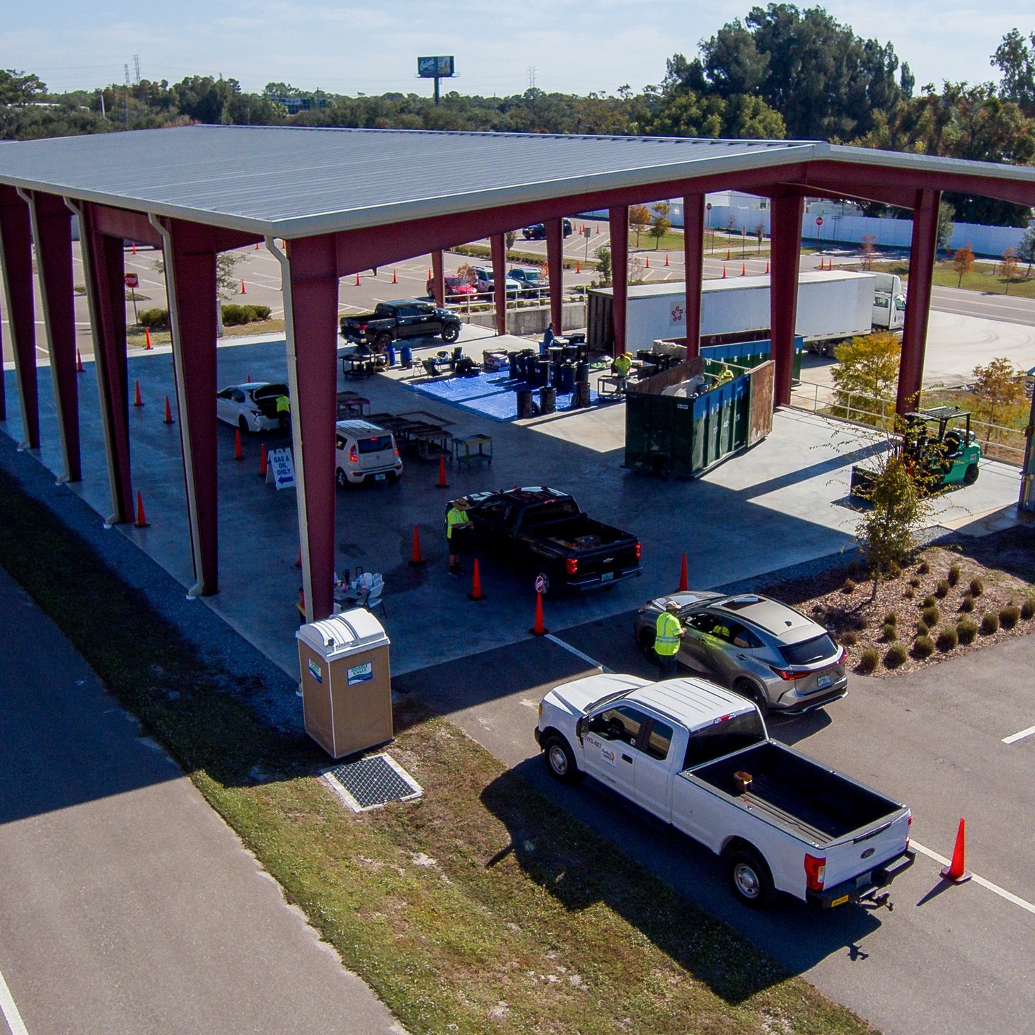 Hazardous Waste Drop Off Center- Cars driving under awning